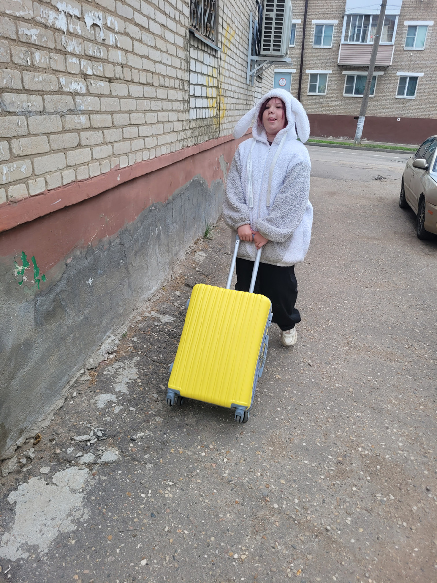 Идет довольная со своим чемоданом. Выбрали яркий для настроения. Это вообще наш первый опыт. Посмотрим, что из этого выйдет. 