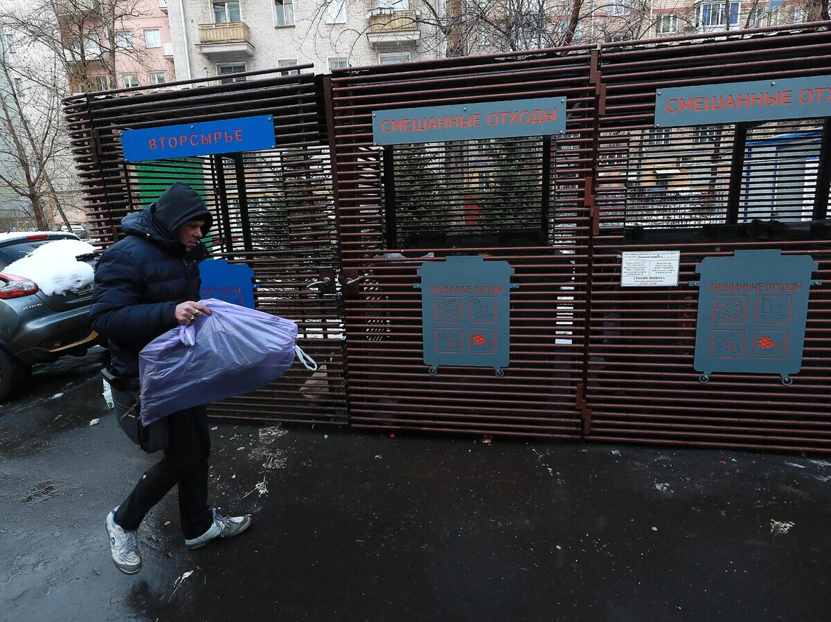    Мужчина несет мусор к контейнерам для раздельного сбора отходов в одном из дворов в Москве | © РИА Новости / Антон Денисов