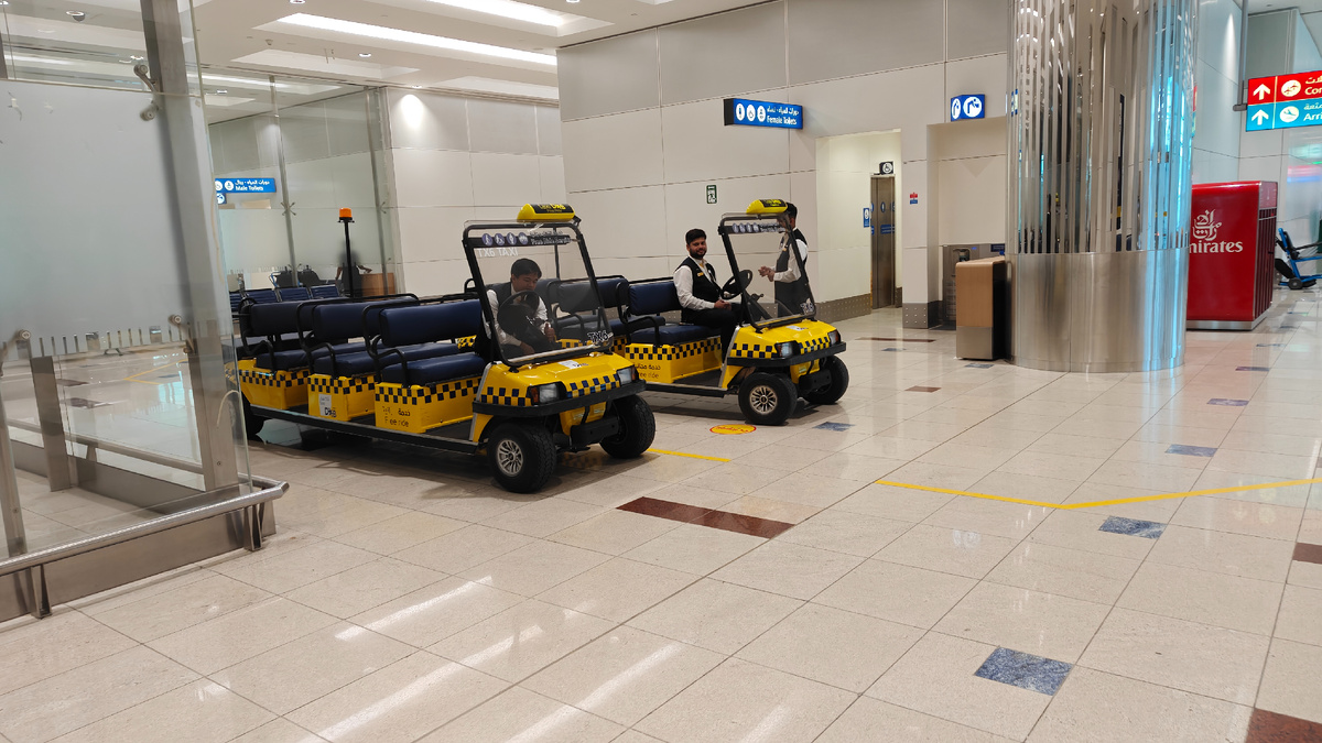 Первое, что встречает в галереях DXB, эти жёлтые электрокары. Бесплатный «free ride» развозит тех, кому тяжело идти до гейтов и выходов. Аэропорт огромный, и такие машинки здесь не роскошь, а необходимость.