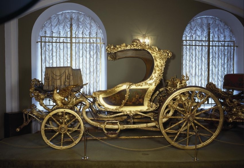 Коляска двухместная. Англия.
Время производства
1770-е гг.
Материал
Клен, бархат, бронза, железо.
Техника изготовления
Резьба по дереву, живопись маслом, позолота по левкасу.
Размер
Длина: 410,0 см; ширина: 190,0 см; высота: 240,0 см.
Принадлежность
Подарена графом Григорием Григорьевичем Орловым императрице Екатерине II.