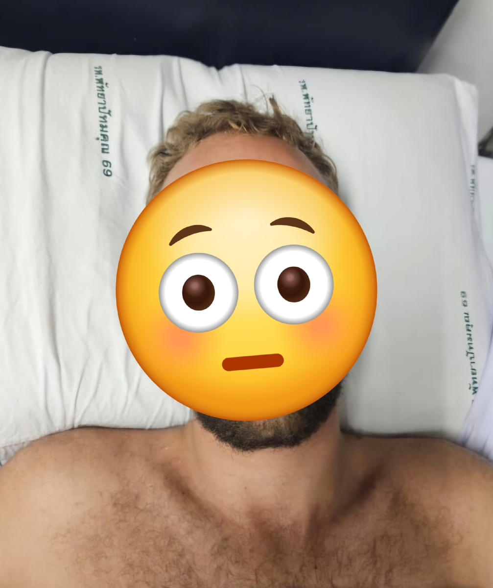 Лежит на подушке с фирменной наволочкой и казенными надписями на тайском языке. 