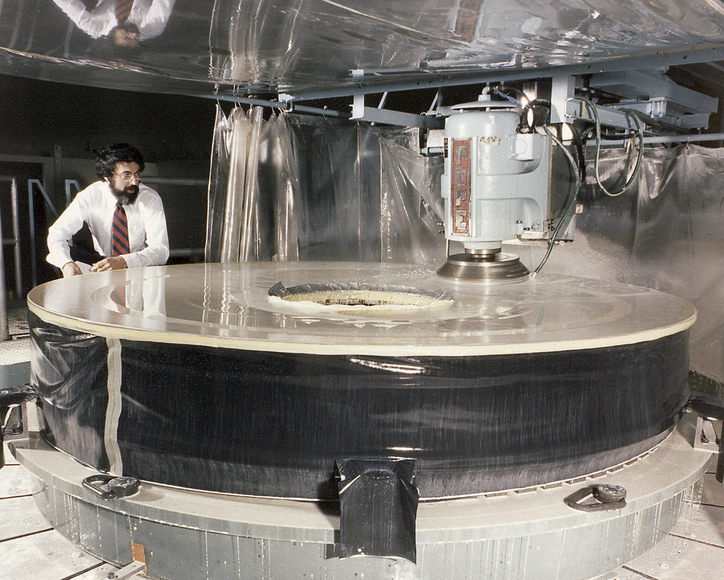 Процесс оптической полировки на заводе компании Perkin-Elmer в начале 1980-х годов. На этом этапе закладывалась та самая микроскопическая погрешность, которую позже пришлось исправлять прямо на орбите.  science.nasa.gov