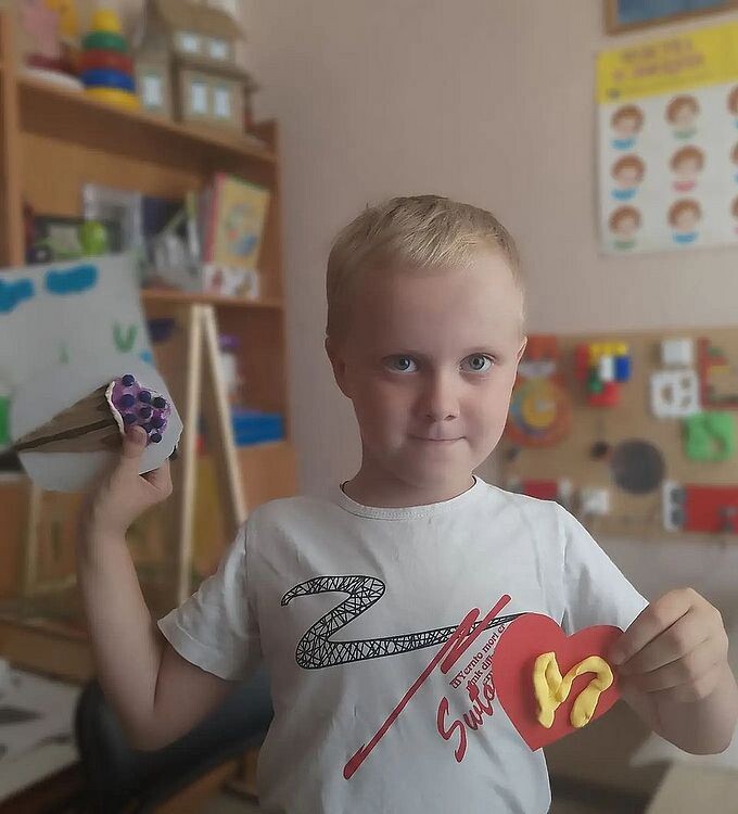 Мальчик показывает созданные методом пластилинографии аппликации мороженого