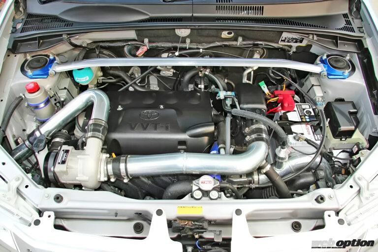 Главная звезда подкапотки — центробежный компрессор HKS GT Supercharger. Так как bolt-on комплектов на Succeed не делают, мастерам пришлось кастомно варить все пайпы и фрезеровать кронштейны, чтобы всё встало красиво и надежно.