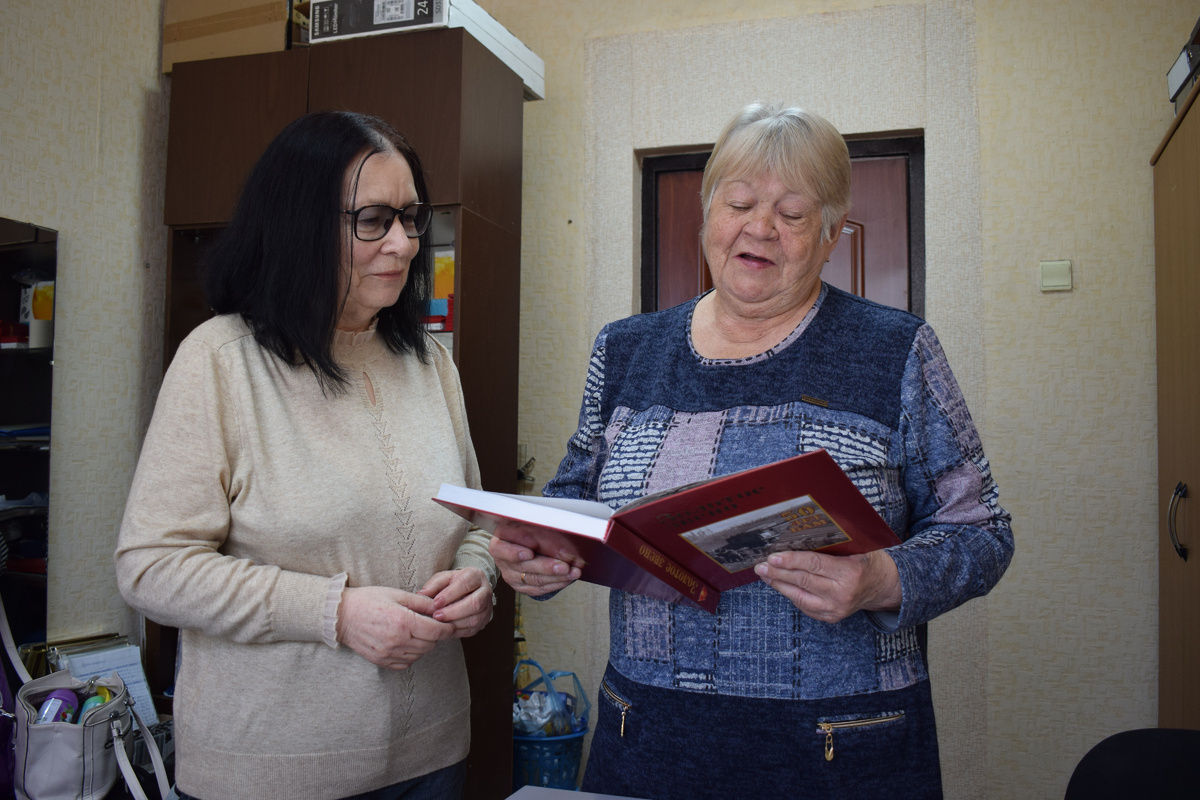 Галина Подъельная вручает Александре Мавриной памятную книгу о бамовцах