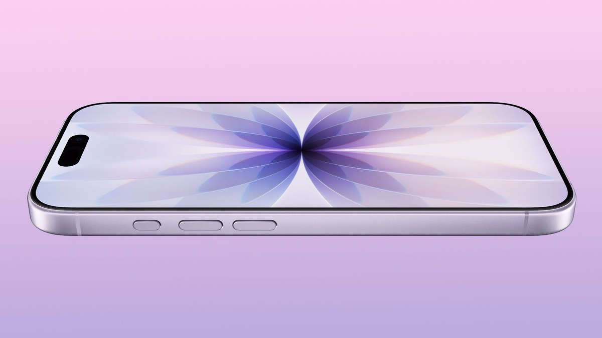    Silver smartphone lying flat on a pink-to-purple gradient background, displaying a purple abstract wallpaper.