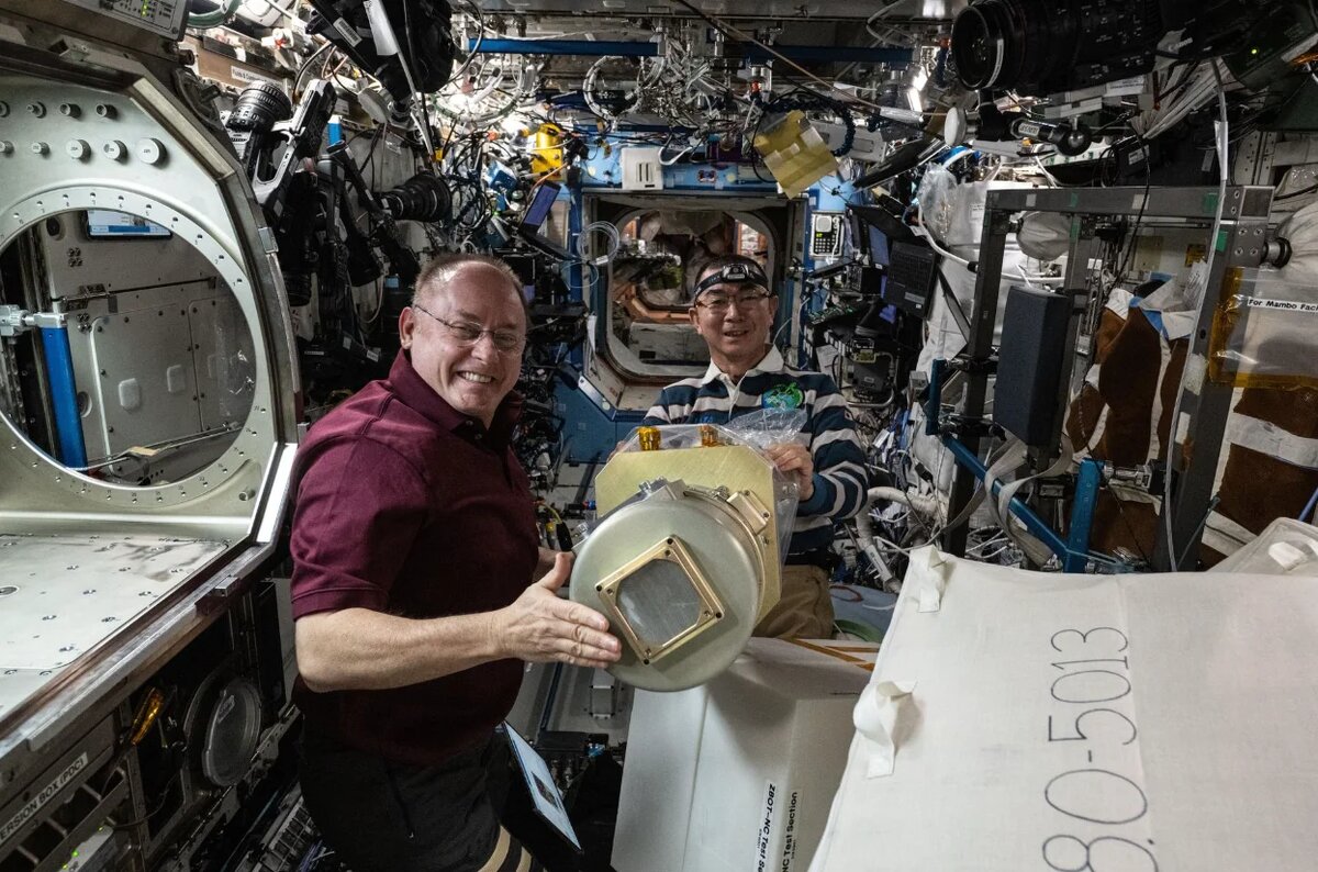 Астронавт NASA Майк Финке и астронавт Японского агентства аэрокосмических исследований Кимия Юи работают над оборудованием для исследования резервуара с нулевым уровнем испарения Источник: NASA