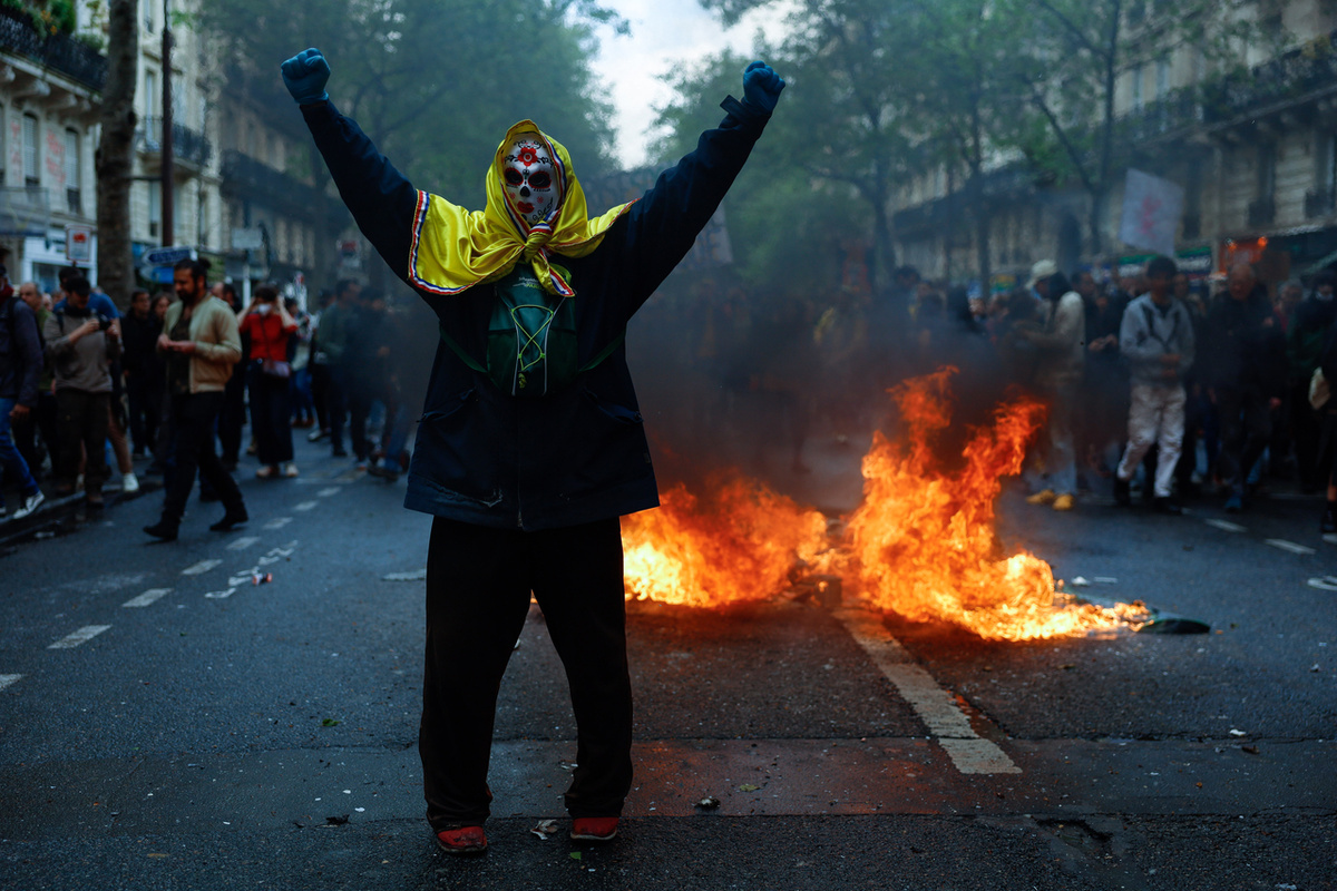 Демонстранты принимают участие в первомайской акции протеста в Париже 1 мая 2023 года на фоне продолжающегося уже несколько недель общественного возмущения в связи с законом о пенсионной реформе, повысившим пенсионный возраст во Франции с 62 до 64 лет (Getty Images)