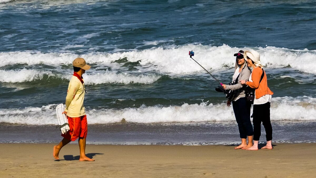 Девушки делают селфи на пляже Южно-Китайского моря в Дананге © Sputnik / Александр Вильф