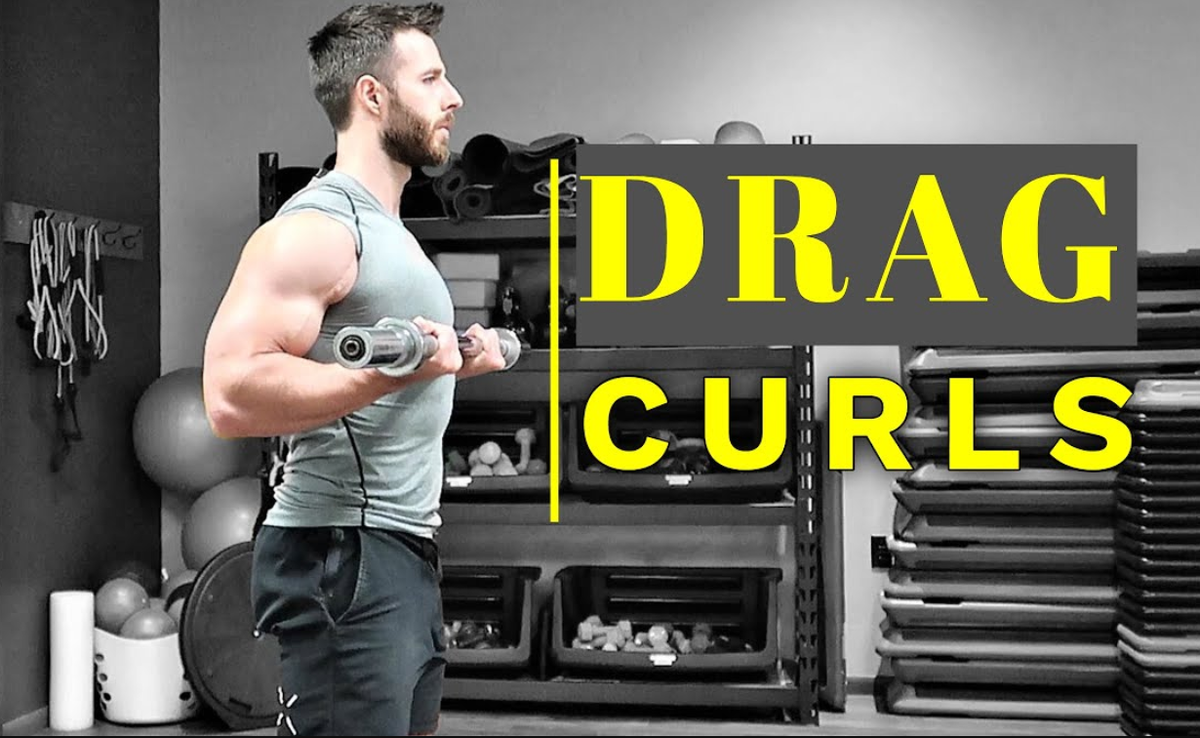 Drag curls — это упражнение для бицепса, при котором вес «перетаскивают» вверх по телу, а локти отводят назад. Оно акцентирует работу на длинной головке бицепса, что способствует формированию «пика» мышцы. 