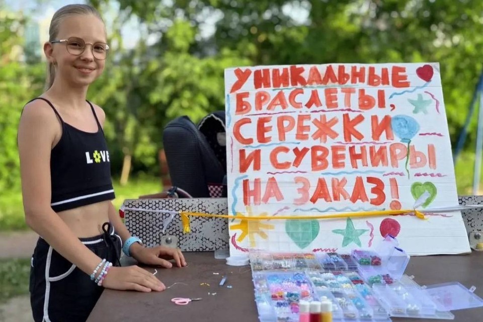    Девочка плетет украшения из бусин и продает их во дворе своего дома. Виктория МИНАЕВА