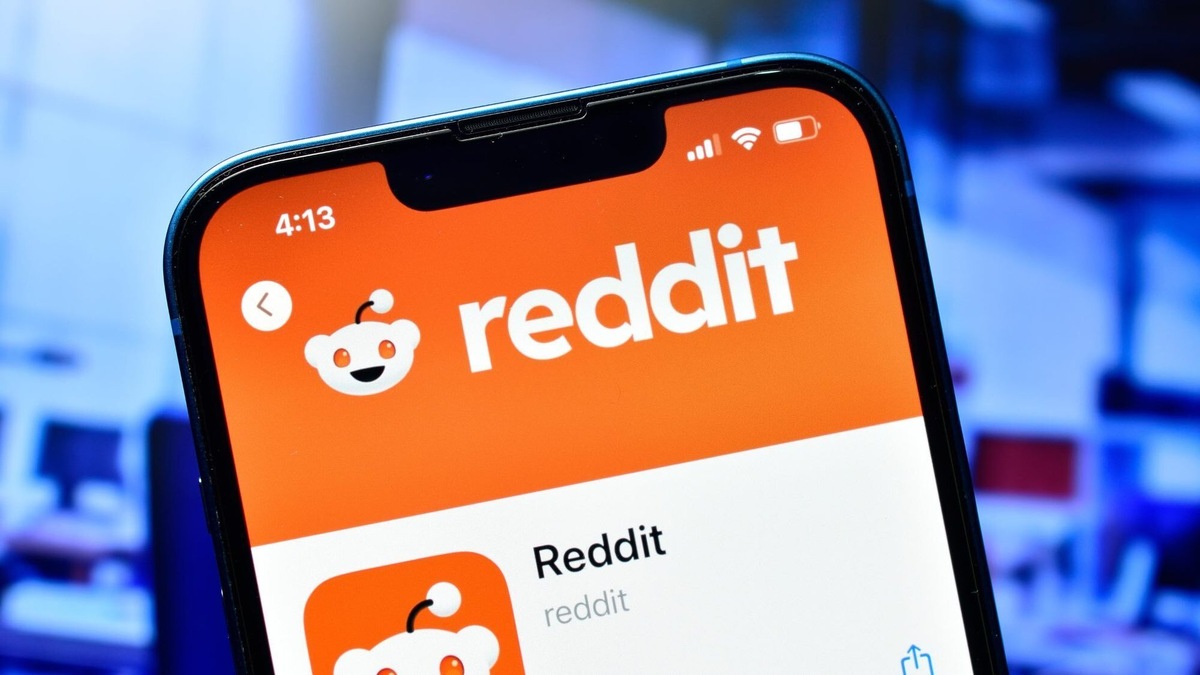 Смартфон с открытым приложением Reddit на фоне размытого интерфейса