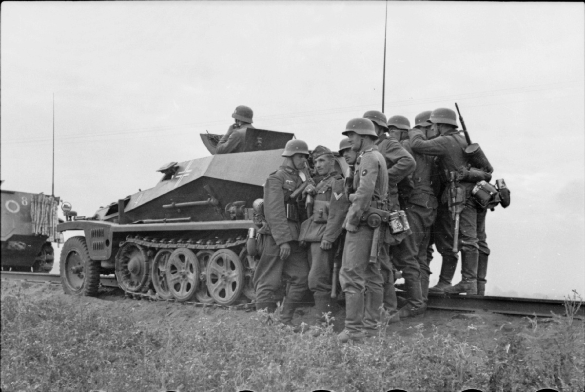 Солдаты вермахта у бронемашины Sd. Kfz. 253 перед железнодорожным мостом через реку Буг у Бреста. 22 июня 1941 года.