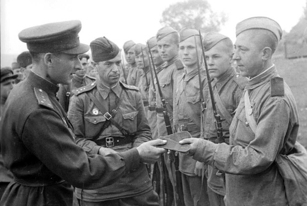 Бойцы и командиры Красной Армии в переходной форме весны-лета 1943 года - гимнастерки старого образца с отложным воротником, но уже с погонами.