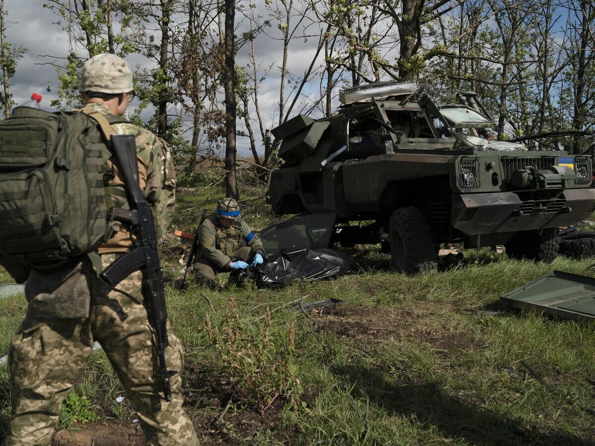    Украинские военнослужащие рядом с уничтоженным бронетранспортером ВСУ в Харьковской области | © AP Photo / Leo Correa