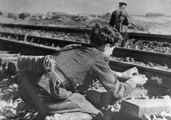    Подрывники бригады Народные мстители им. Воронянского закладывает взрывчатку под рельсы / Евгений Коктыш РИА Новости