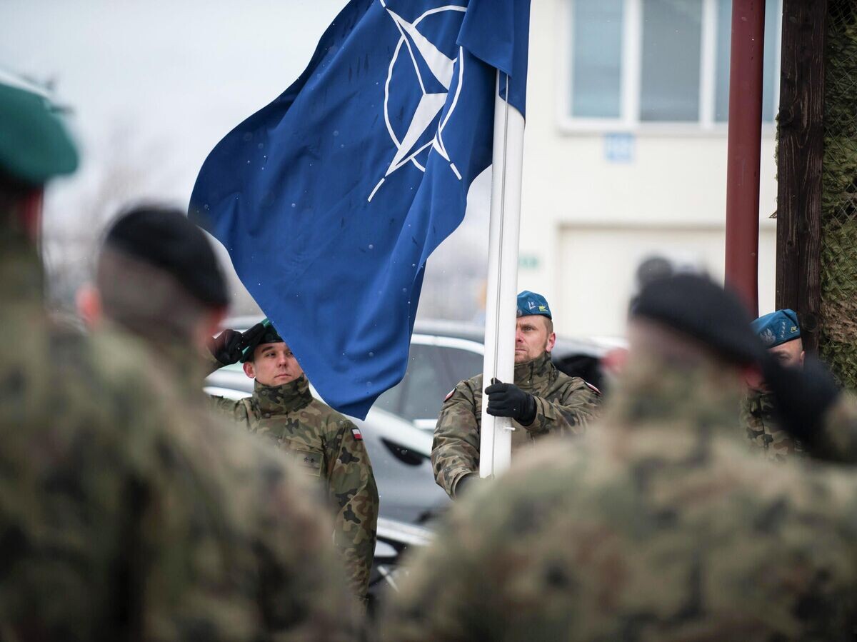    Польские военнослужащие поднимают флаг НАТО во время торжественной церемонии празднования 20-летия присоединения Чехии, Венгрии и Польши к блоку | © Фото : U.S. Air Force / Tech. Sgt. Clayton Lenhardt