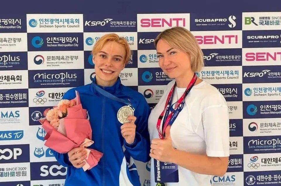 Анна Мишустина (ФП) и Диана Слисева (ФФК) со своими тренерами на чемпионате мира – 2026