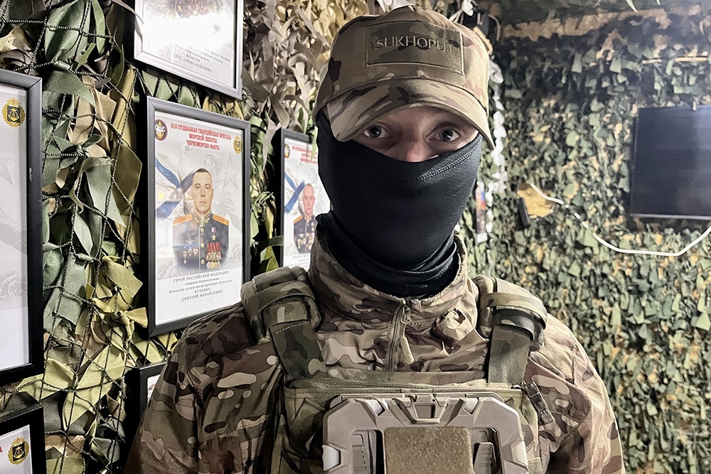    Морпех с позывным "Кинжал" у стенда с портретами героев 810-й бригады. / Анна Ковалева/РГ