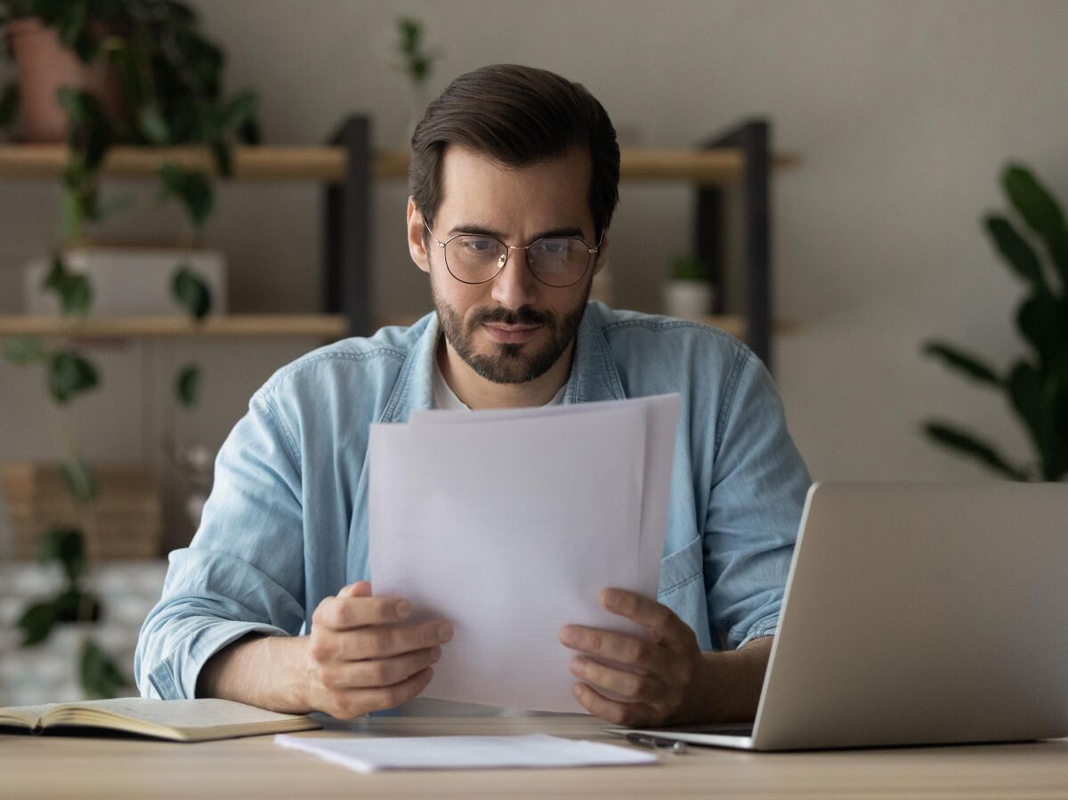    Мужчина изучает документы | © iStock.com / fizkes