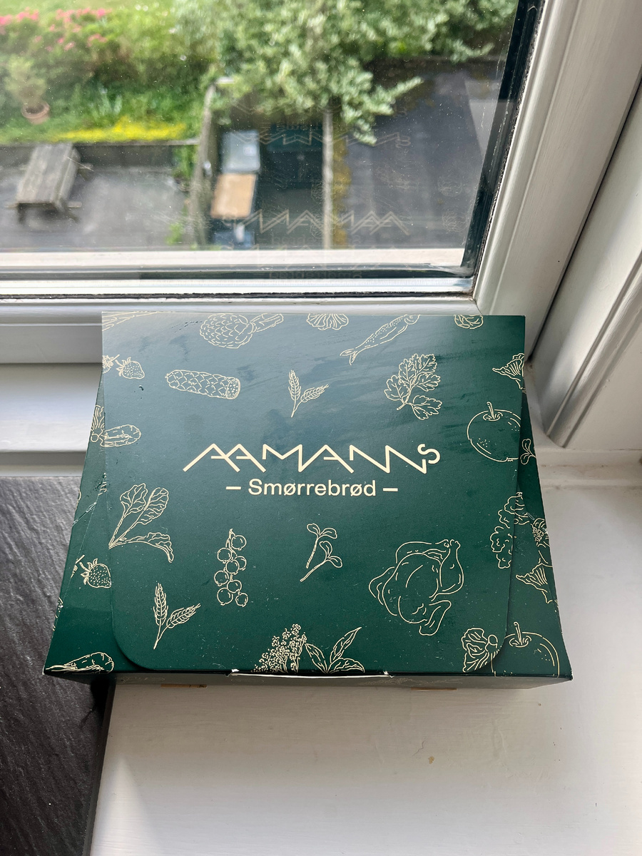 Фирменная коробочка из заведения Aamanns: когда даже стильная упаковка намекает на то, что внутри скрывается что-то изысканное. Фото автора.
