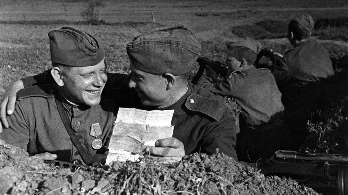    13 апреля 1944 года. Батальон автоматчиков 36-й гвардейской танковой бригады 4-го механизированного корпуса. Гвардии красноармеец Василий Подрезов делится с сослуживцем Михаилом Щербаковым известиями, полученными от родных в письме / Фото: Ольга Ландер / РИА Новости