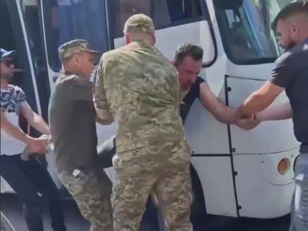    Сотрудники ТЦК Украины заталкивают мужчину в автобус | © Кадр видео из соцсетей