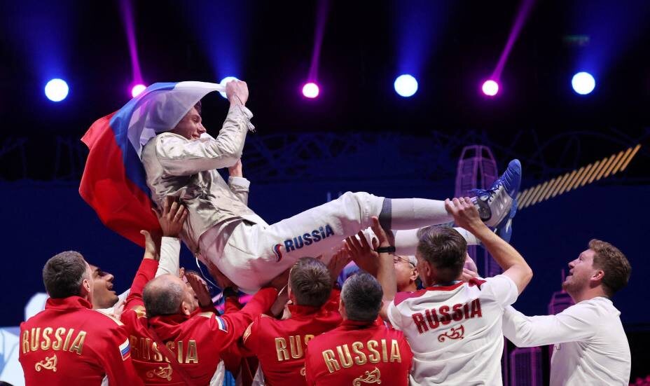    Павел Граудынь из России празднует с товарищами по команде победу в финале мужской сабли на ЧМ 2026. Фото: REUTERS/Tyrone Siu