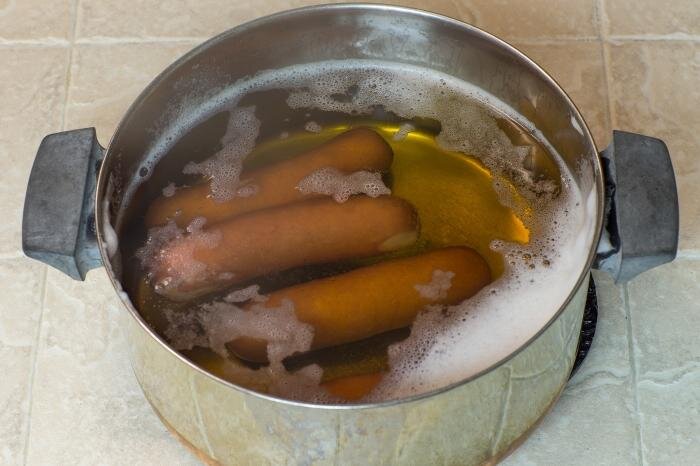 сардельки вареные. вареная сарделька в воде. сосиска в воде. сосиски варятся. сардельки варят в кипящей воде.