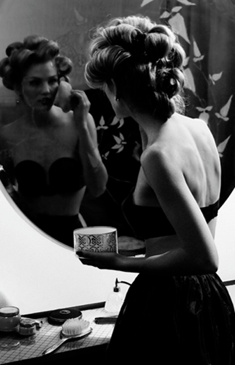 Девушка красится перед зеркалом