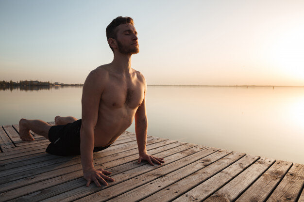 Фото https://ru.freepik.com/free-photo/handsome-young-sportsman-make-yoga-exercises-at-the-beach_8070656.htm