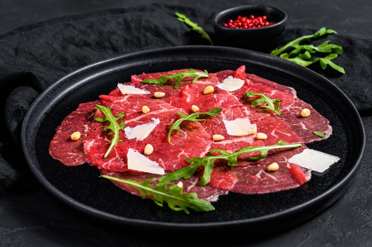 Вариант сервировки Карпаччо с листиками рукколы, пармезаном и кедровыми орешками