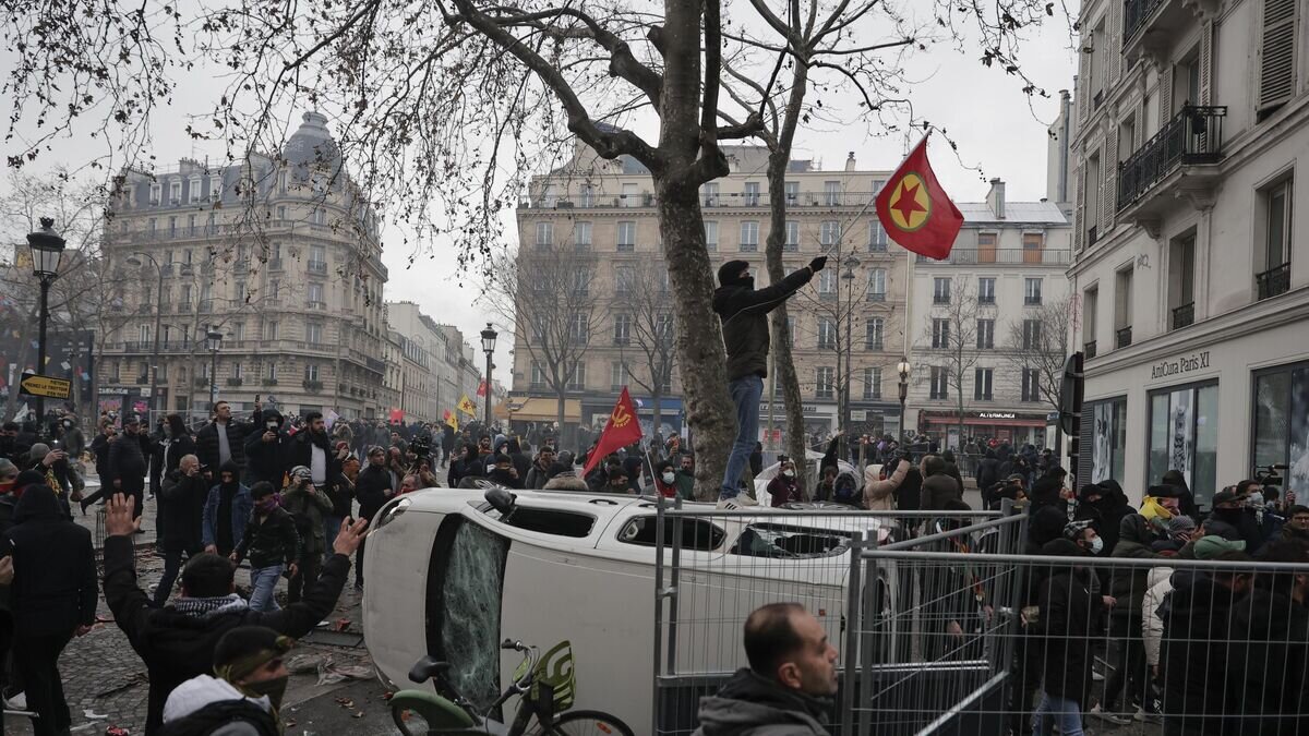    Демонстрант с флагом Рабочей партии Курдистана во время акции протеста в Париже© AP Photo / Lewis Joly