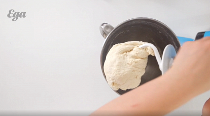 2. В муку влить дрожжевую смесь, добавить щепотку морской соли и размешать все блендером. Достать тесто и размять на столе (это позволит обогатить его кислородом). Затем тесто сформировать в виде шара, упаковать в пищевую пленку и отправить в теплое место на час.