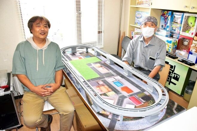 Такеши Нономия (слева) и Тецуо Яги рассказывают о модели магнитолевой системы N калибра, показанной в центре отделения их компании для разработки 25 августа в районе Хигаси в Нагое.