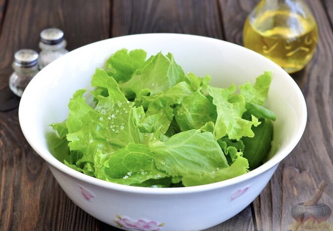 Чистые салатные листья выложите в удобную посуду, заправьте оливковым маслом, солью и перцем, перемешайте.
