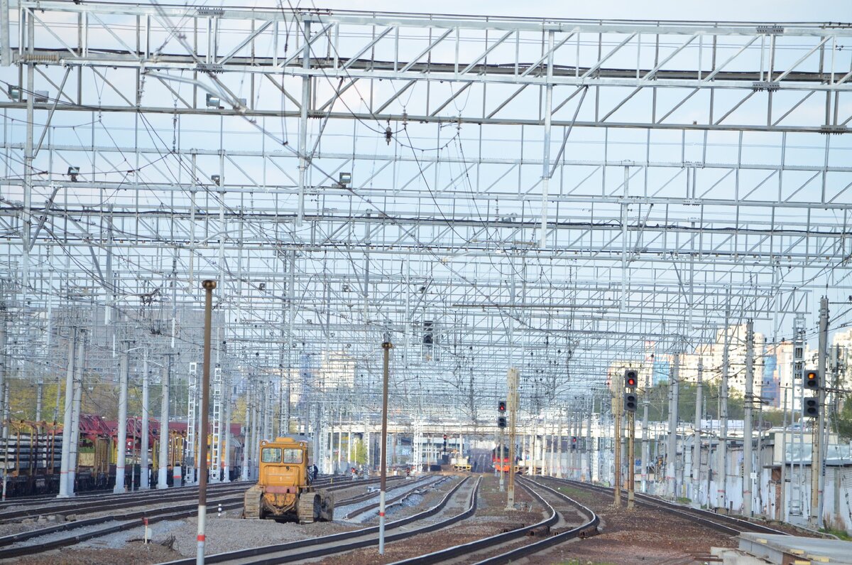 Время спуститься вниз, га платформу. Вблизи виден трактор, вдали маячит нечто, похожее на Демих. Слева на запасном пути стоят вагоны с рельсами и шпалами, кажись.