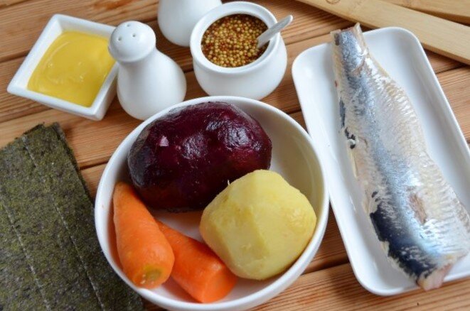 Расстелите на столе циновочку, застелите ее пищевой пленкой. Положите лист нори, сверху распределите половину тертой свеклы, соль, нанесите майонезную сеточку. У меня два листа нори, поэтому все продукты я делю на две части. Если овощи некрупные, то отварите чуть больше.