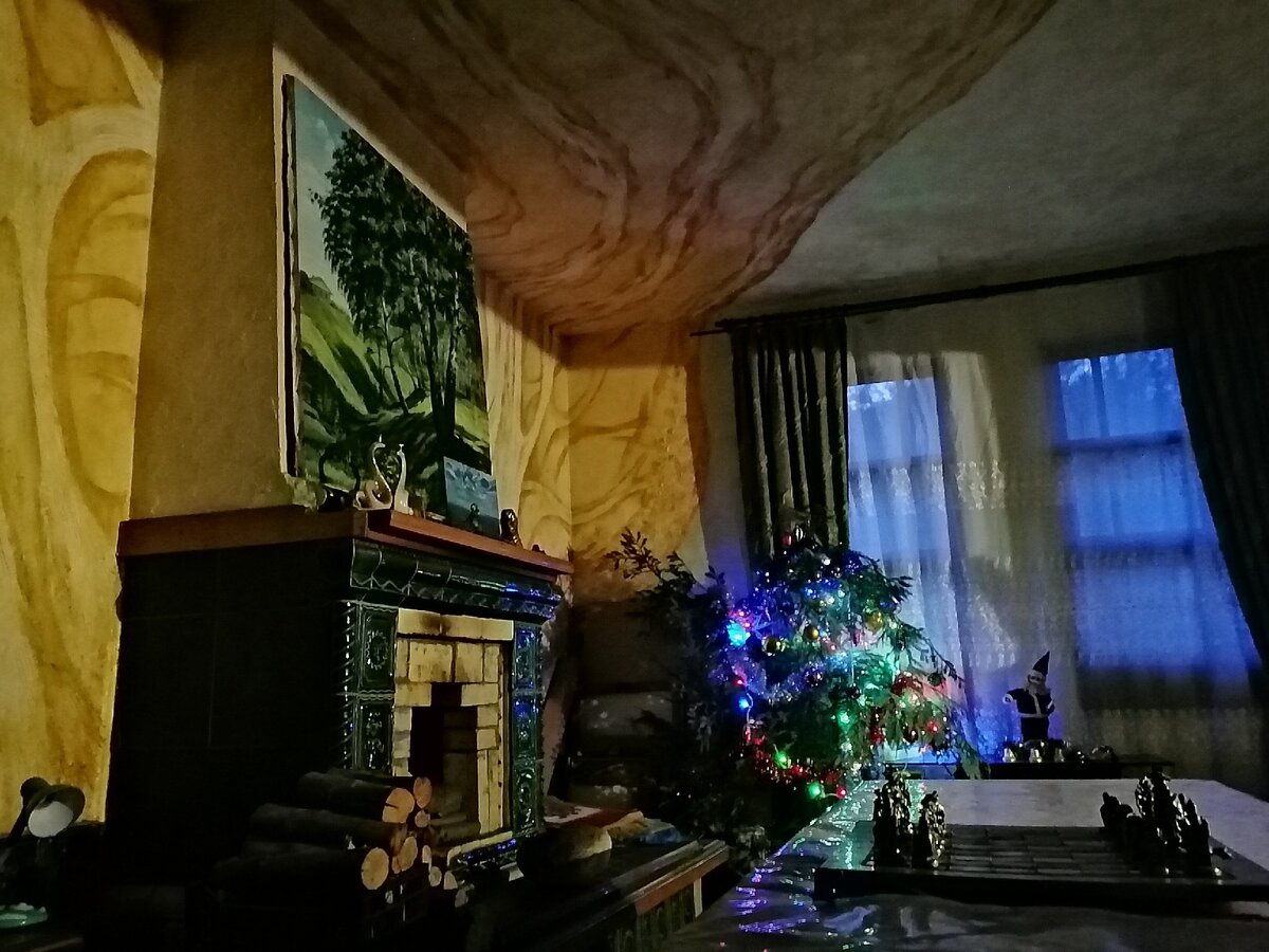 Фото автора. Блеск новогодних гирлянд, вечернего света из окон, теплого освещения делает камин самым праздничным уголком в доме.