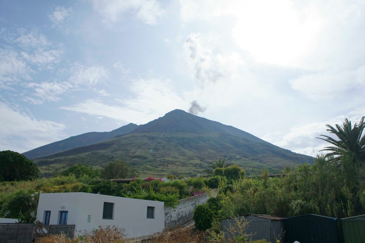 Так вулкан выглядит днем и краешек деревеньки. принимающей туристов