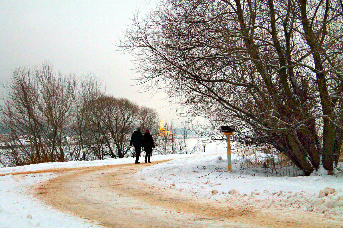 Заснеженная дорога. Вдали виднеются яркие огоньки здания Речного вокзала. Фото автора