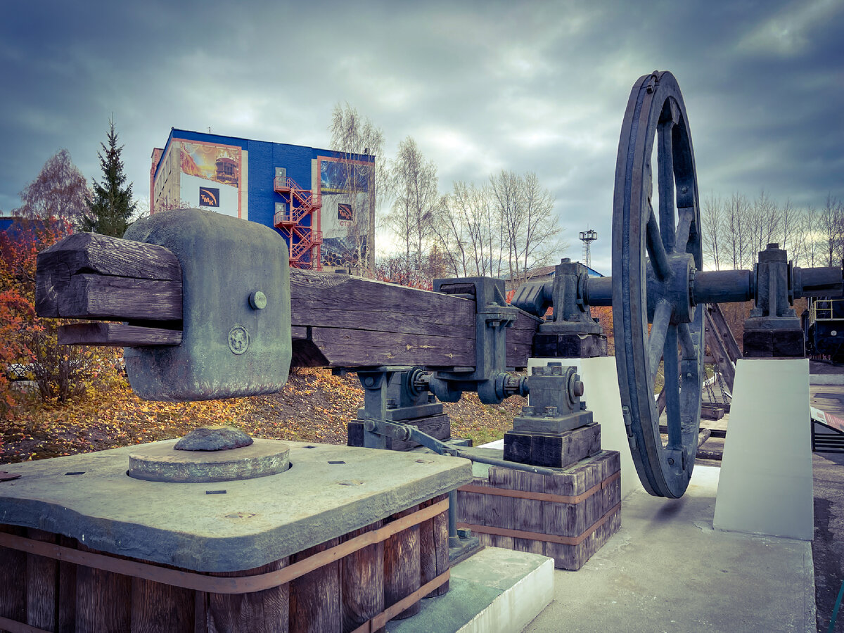 Точная копия кричного молота XIX века. После кричного горна, в котором чугун рафинировался и обезуглероживался, полученные крицы проковывались молотом для уплотнения и выжимания шлака, которого оставалось до 2%. Большое колесо вращалось ременной передачей от гидроустановки, кулаком опускало край молотовища, противоположный голове молота, а когда кулак отпускал молотовище, голова под собственным весом ударяла по крице. 