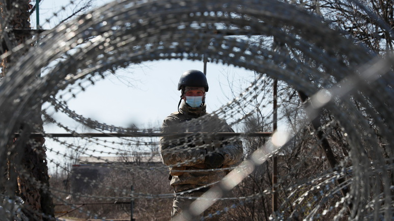 A member of the Ukrainian State Border Guard Service wearing a protective mask is seen at the contact line between Ukrainian troops and pro-Moscow rebels, after Ukraine's government banned people registered in separatist-held territories from entering government-controlled areas to stop coronavirus (COVID-19) spread, in Mayorsk, Ukraine March 17, 2020. REUTERS/Gleb Garanich