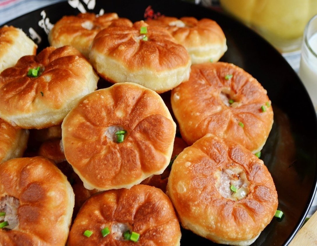 Ингредиенты:  
Мука — 3–3,5 ст 
Вода — 1 ст 
Растительное масло (в тесто) — 3 ст. л. 
Соль (в тесто) — 0,5 ч. л 
Свежие дрожжи — 20 г 
Свинина жирная — 250 г 
Говядина — 250 г 
Лук — 2 шт. 
Вода (в фарш) — 100 мл 
Соль (в фарш) — по вкусу 
Перец черный молотый (в фарш) — по вкусу 
Рафинированное масло (для жарки) — 1 ст 

Приготовление: 

Жирный кусочек свинины и кусочек говядины перекрутите на мясорубке с крупной решеткой. Понадобится одна огромная луковица или две средних. 
В теплой воде растворите соль и свежие дрожжи. Чтобы дрожжи быстрее "заиграли", можно добавить пару щепоток сахара. 
Влейте растительное масло, всыпьте муку и замесите мягкое и пластичное тесто. 
Накройте его салфеткой и уберите в теплое место на 1 час. 
Пока тесто подходит, сделайте фарш для беляшей. Очистите лук, порежьте его максимально мелко. К мясному фаршу добавьте лук, соль, перец черный молотый и холодную воду. Хорошо перемешайте фарш. 
В конце перемешивания "выбейте" фарш (поднимайте и бросайте его в миску несколько раз), тогда он будет однородным и сочным. 
Спустя 1 час осадите тесто руками, разделите на небольшие шарики размером чуть больше грецкого ореха. Муку не нужно использовать, смажьте стол маслом, чтобы тесто не прилипало. Приступаем к лепке. Шарик теста пальцами расплющите по столу. 
Положите столовую ложку фарша. 
Одной рукой возьмите край теста, а другой подавайте тесто и прищипывайте его с краю, так двигайтесь по кругу. В итоге у вас получится по центру отверстие, а по периметру — складочки. 
Хорошо разогрейте масло, убавьте огонь до минимального. Выкладывайте беляши отверстием вниз и жарьте долго до румяного цвета. 
Переверните беляши и обжарьте с другой стороны. Количества масла должно быть много, чтобы беляши жарились со всех сторон. 
Готовые беляши выкладывайте на салфетку, чтобы убрать лишний жир. Потом переложите в большую тарелку и подайте к столу с кувшином молока. 

Приятного аппетита!
