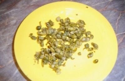     Свежие каперсы хорошенько вымыть под проточной водой и на разделочной доске ножом мелко-мелко нарезать. Хочу заметить что, чем мельче вы нарежете их тем лучше для блюда, поэтому не ленимся а тщательно измельчаем их. Можно воспользоваться и блендером, но он их перемелет в кашу, а нам нужны мелкие кусочки.   