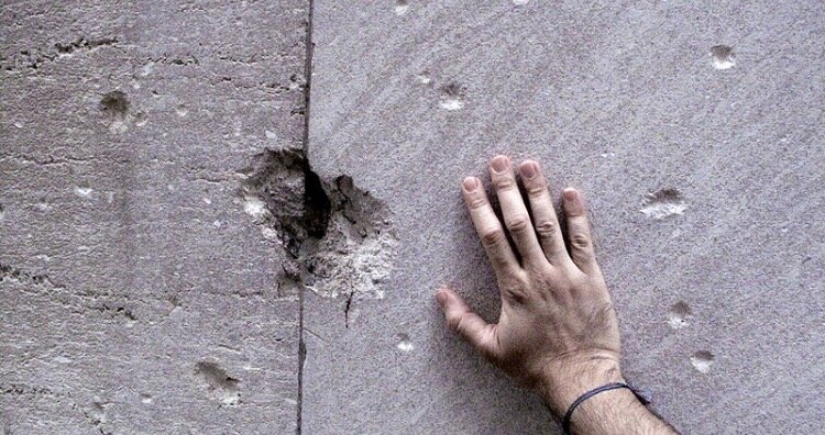 ПоделитьсяМесто взрыва на Уолл-стрит в 1920 году. Знаки все еще видны сегодня. Рука показывает шкалу оценок. Изображение предоставлено: NortonJuster7722 через Википедию