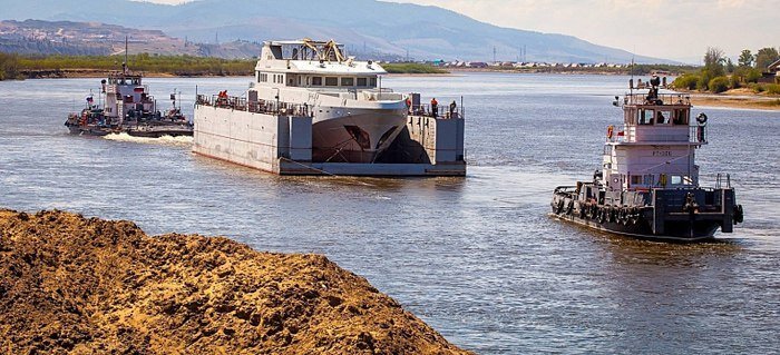 Доставка яхты на полупогружной барже с помощью буксиров по реке