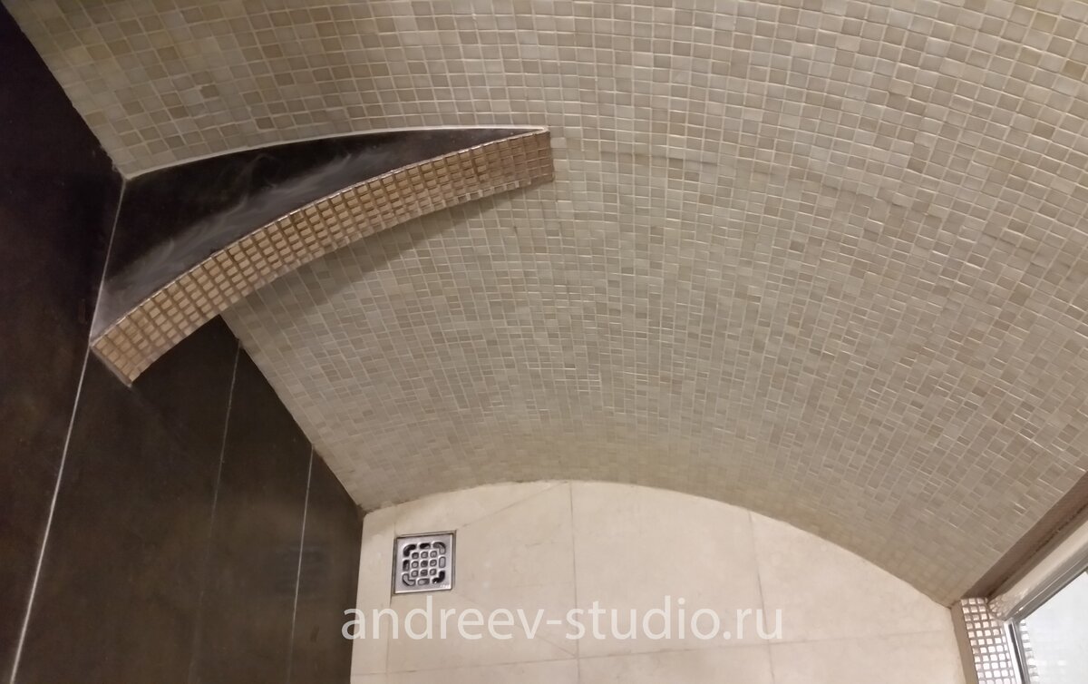 Полка радиусной формы внутри встроенной душевой кабины, облицованной керамогранитом и мозаикой (фото авторов).