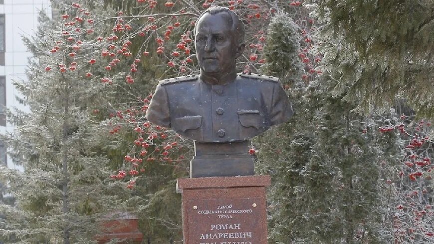 Памятник прокурору Руденко среди кроваво-красных кустов рябины
