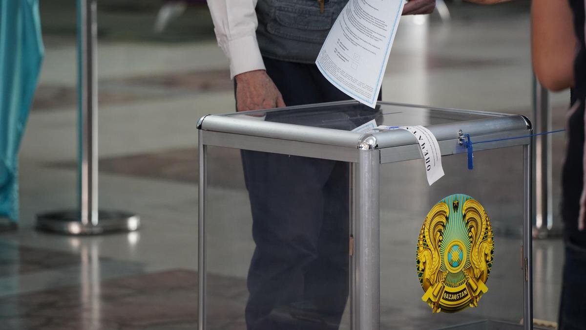    Женщина бросает в урну бюллетень:NUR.KZ / Владимир Третьяков
